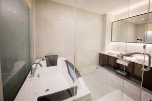 A modern bathroom with a large bathtub, two sinks, and a large mirror. - Binjiang Celebrity Holiday Hotel (Nanbu County)