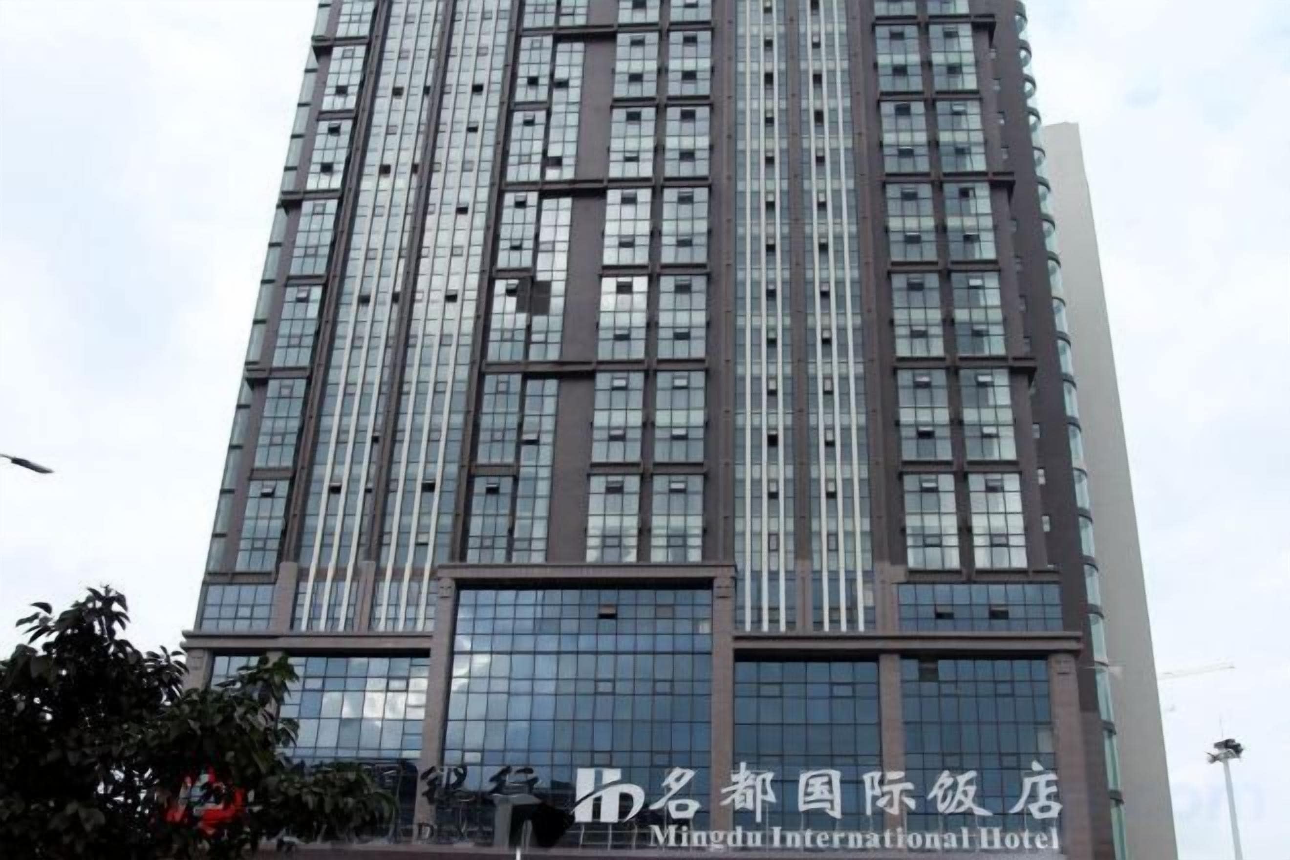 A tall building with a modern architectural design, featuring a large glass facade and multiple windows.
