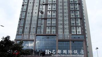 A tall building with a modern architectural design, featuring a large glass facade and multiple windows.