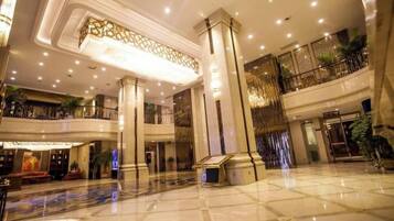 A spacious lobby with a high ceiling, large columns, and a polished floor.
