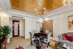 A dining area with a wooden ceiling, a chandelier, and a dining table with chairs. - Mingdu International Hotel (Bazhong)