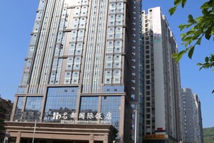 Un edificio de gran altura con varios pisos, destacando un cartel con el nombre del Hotel Internacional Mingda.