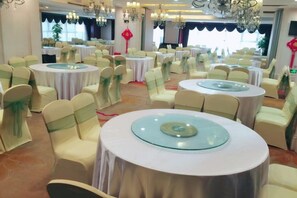 A banquet hall with round tables, chairs, and chandeliers. - Mingdu International Hotel (Bazhong)