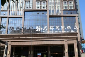 A building with a sign for the Mingdu International Hotel. - Mingdu International Hotel (Bazhong)