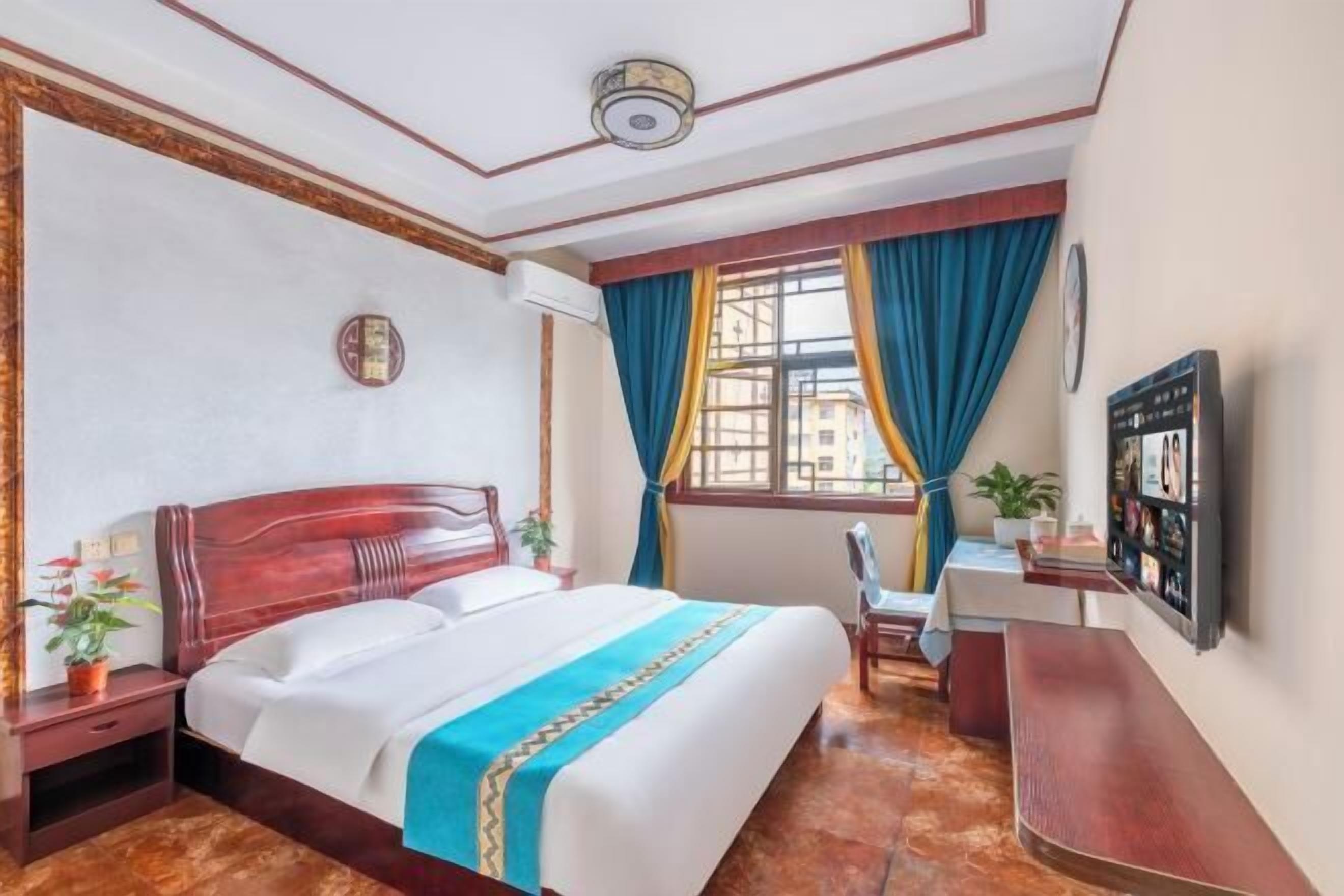 Una camera d'albergo con un letto di legno, una scrivania e una sedia.