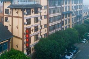 A multi-story building with balconies and air conditioning units. - Jiaxin Hotel (Pingbian)