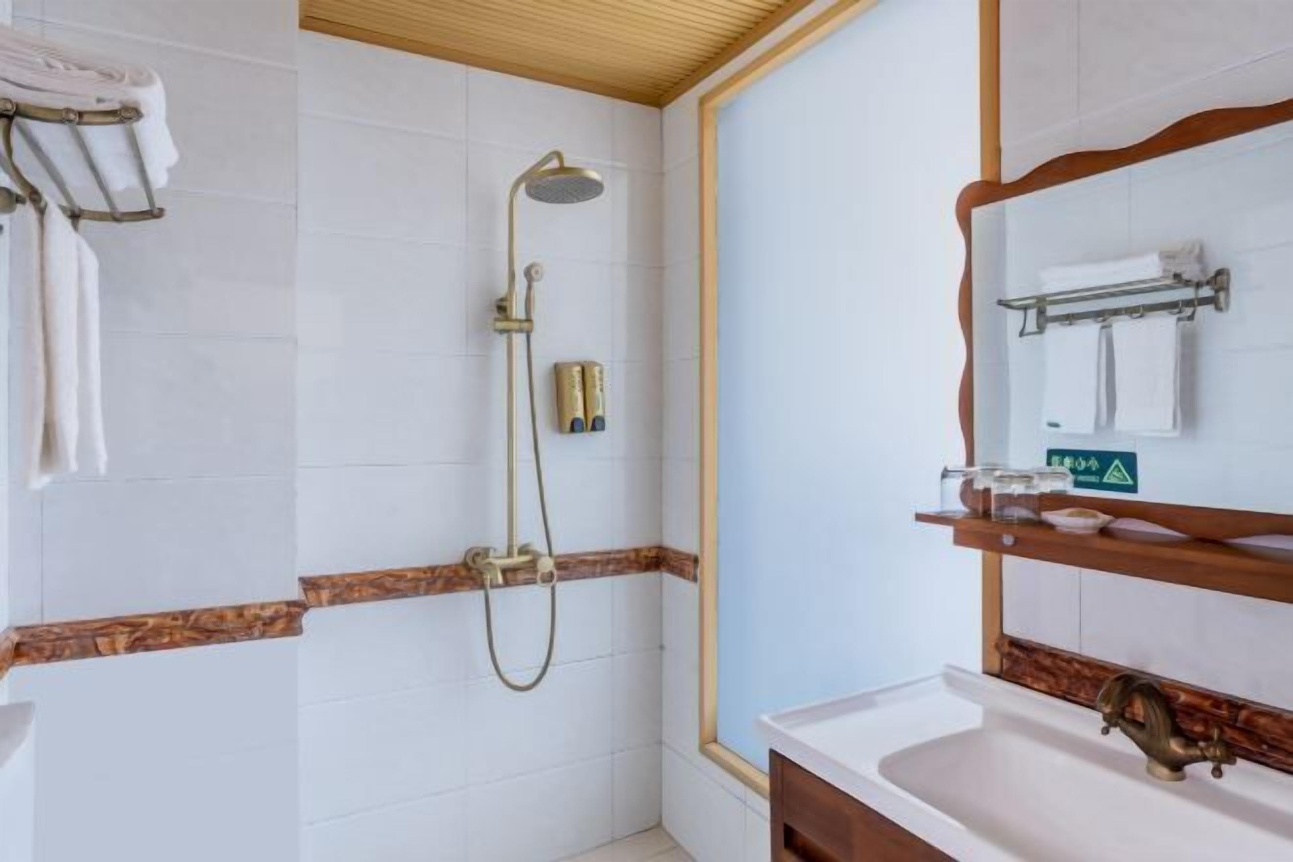 Un baño con ducha, lavabo y espejo.