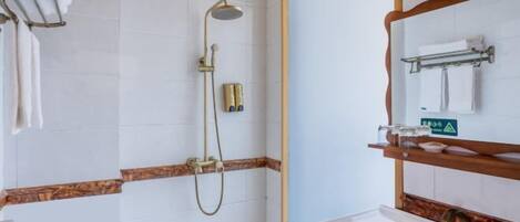 Un baño con ducha, lavabo y espejo.