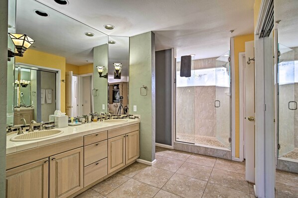 A modern bathroom with a double sink vanity, a walk-in shower, and a large mirror.