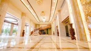 A spacious lobby with marble floors, a grand staircase, and large columns. - Wenhe Hotel (Hepu)