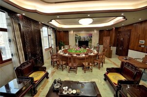 Un comedor de estilo tradicional con una mesa redonda, sillas de madera y un televisor.