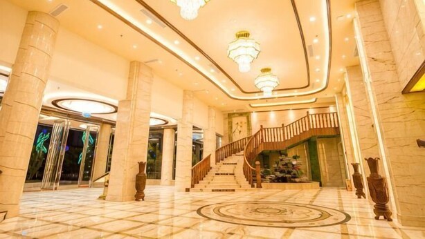 A spacious lobby with marble flooring, large columns, and a grand staircase. - Wenhe Hotel (Hepu)