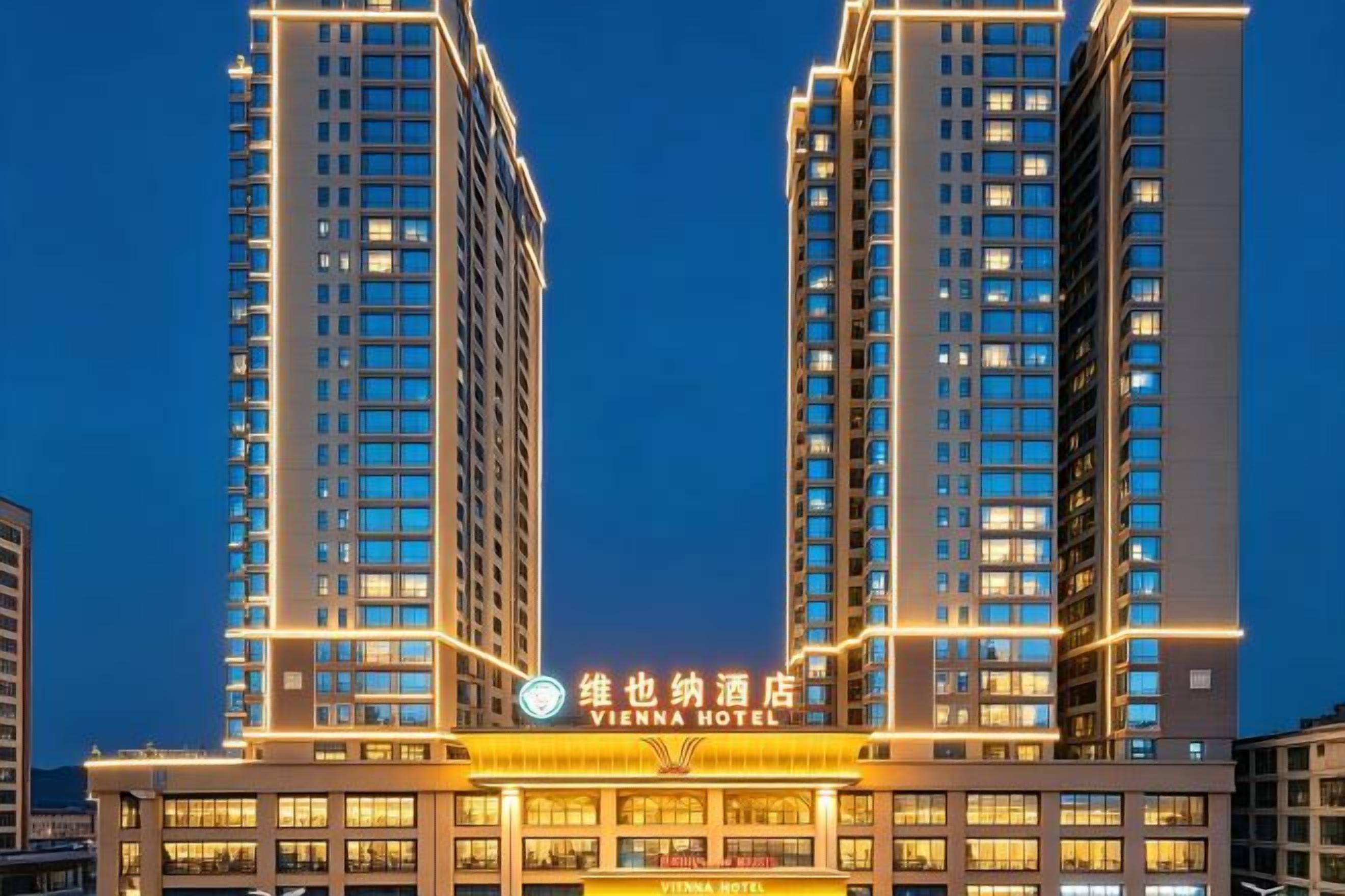 A hotel building with multiple floors and a prominent sign at the entrance.