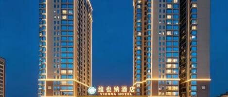 A hotel building with multiple floors and a prominent sign at the entrance.