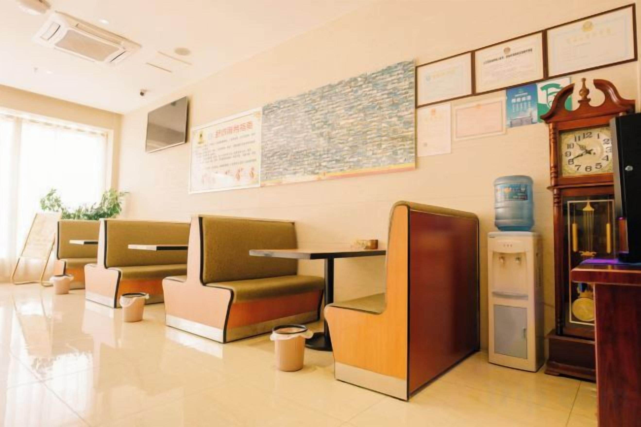 A hotel lobby with seating areas, a water dispenser, and a clock on the wall.