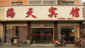 Un hôtel reconnaissable à son grand panneau rouge et à son entrée en verre.