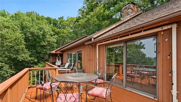 A wooden deck with a glass door, a round table, and chairs. - White River Mountain Manor- Million dollar view (Eureka Springs)