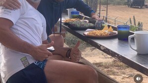 Two people sitting at an outdoor table with food and drinks, overlooking a desert landscape. - Cerritos Baja Eco Pet Friendly Boutique stay (El Pescadero)