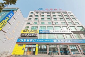 Un edificio de varios pisos con letreros de Bank of Handan y otros negocios.