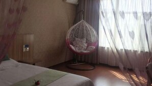 A hotel room with a bed, a hanging chair, and a window with sheer curtains. - Eaka 365 Hotel Daming Damingfu Road (Daming)