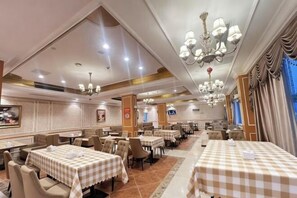 A hotel dining area with multiple tables, chairs, and chandeliers. - Vienna Hotel (Luofu Mountain Scenic Area High-Speed Rail Station Branch) (Boluo)