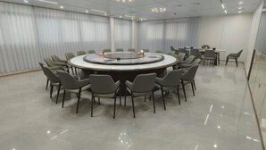 A conference room with a circular table surrounded by chairs, a whiteboard, and a projector. - Anxi Ganglong Grand Hotel (Anxi)