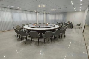 A conference room with a round table surrounded by chairs, a whiteboard, and a projector. - Anxi Ganglong Grand Hotel (Anxi)
