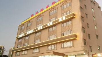 Un hotel de varios pisos con una entrada destacada y señalización.