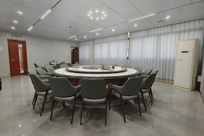 A conference room with a round table surrounded by chairs, a whiteboard, and a door in the background. - Anxi Ganglong Grand Hotel (Anxi)