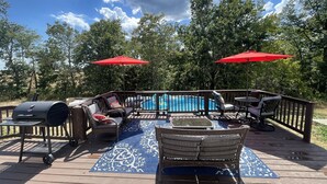 Une terrasse dotée de mobilier d’extérieur, d’un barbecue et d’une piscine.