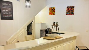 A kitchen with a white countertop, black bar stools, and a hanging light fixture. - Spacious house with jacuzzi 5 minutes from town center. (Fort-de-France)