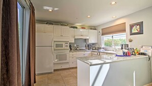 A modern kitchen with white cabinets, a granite countertop, and built-in appliances. - Elegant and spacious two-story suite near Palm Springs (Cathedral City)