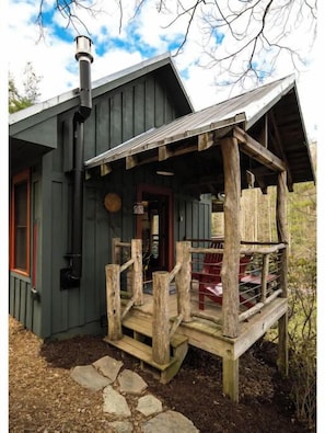Uma cabana rústica com varanda de madeira e chaminé.