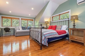 A bedroom with a bed, a desk, a chair, and large windows. - Sunset Cove by Taylor Made Deep Creek (Swanton)