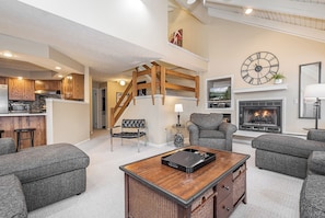 A spacious living room with a fireplace, a dining area with a wooden table, and a kitchen with modern appliances. - 180 Degrees by Taylor Made Deep Creek (Oakland)