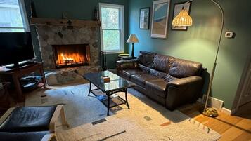 Télévision, cheminée, lecteur de DVD, baby-foot