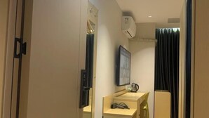 Une chambre d’hôtel équipée d’un bureau, d’une chaise et d’un miroir.
