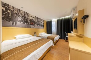 A hotel room with two beds, a desk, a chair, a large window with curtains, a wall-mounted TV, and a vintage street photo. - Xinyi Hotel (Guangzhou)
