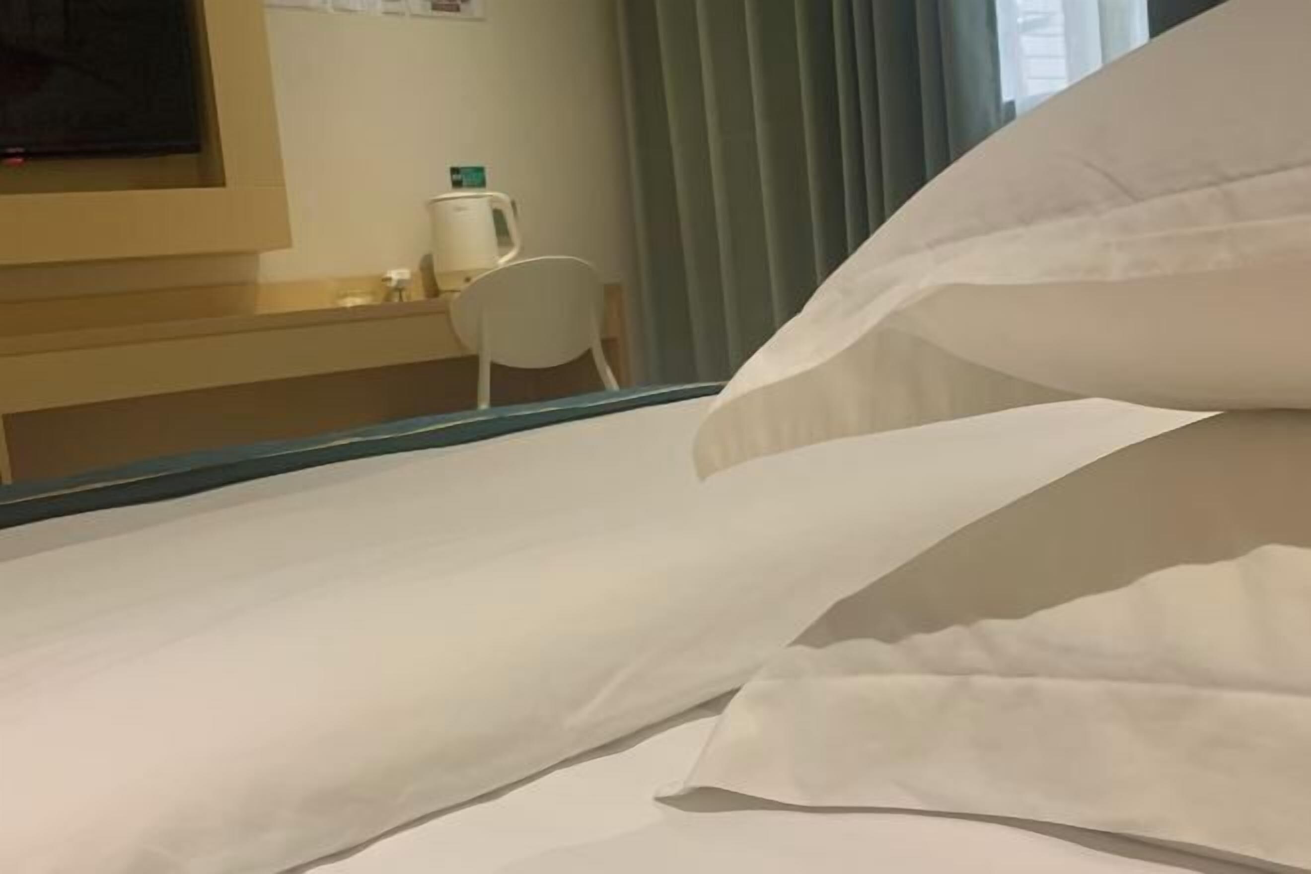 Ein Hotelzimmer mit Bett, Schreibtisch und Stuhl.