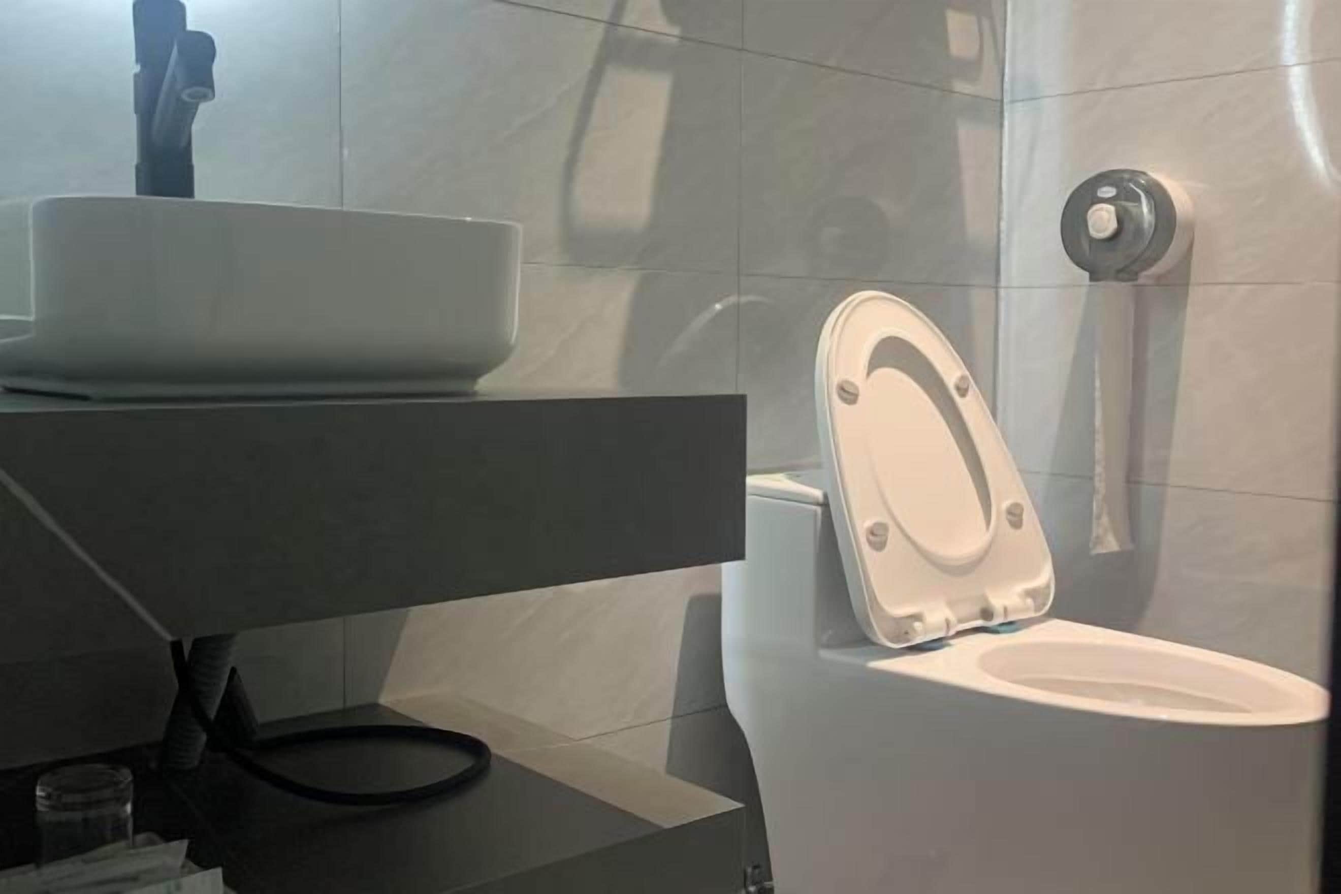 Ein modernes Badezimmer mit Toilette, Waschbecken und Duschbereich.