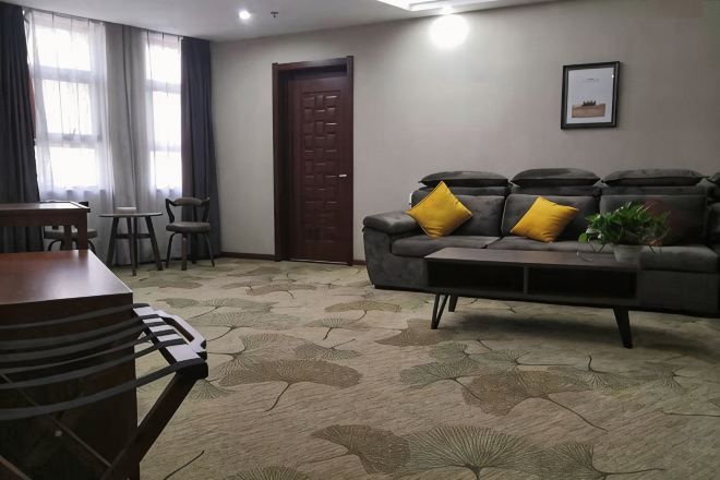 A living room with a sofa, a coffee table, a dining table, and chairs.