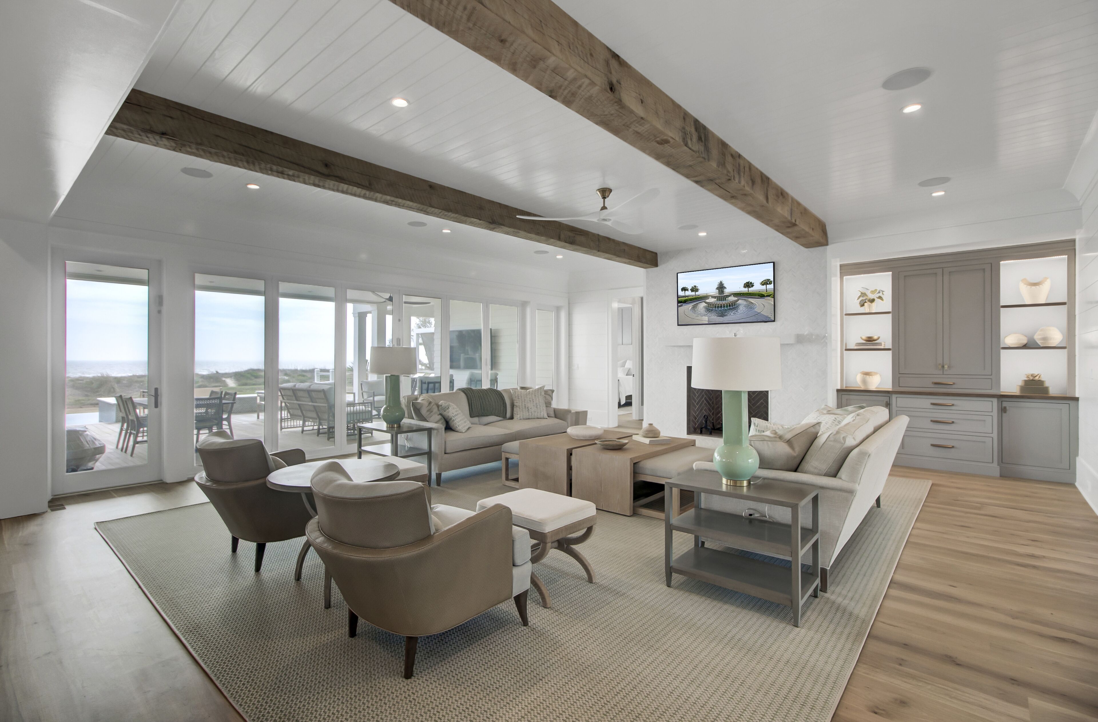 Amplia sala de estar con techos altos, ventanas grandes y una cocina moderna.