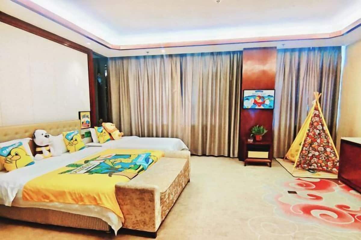 A hotel room with a large bed, a small table, a chair, a TV, and a decorative teepee.