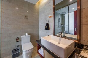 Un baño moderno con inodoro blanco, un lavabo rectangular grande y un espejo sobre él.