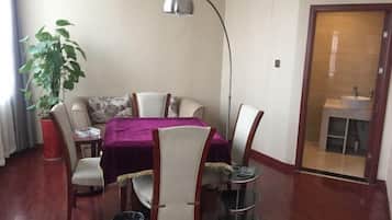 Un comedor con una mesa, sillas, una planta, una lámpara y vistas al baño.