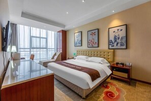 Habitación de hotel con una cama grande, un escritorio y una silla. Hay tres obras de arte enmarcadas en la pared.