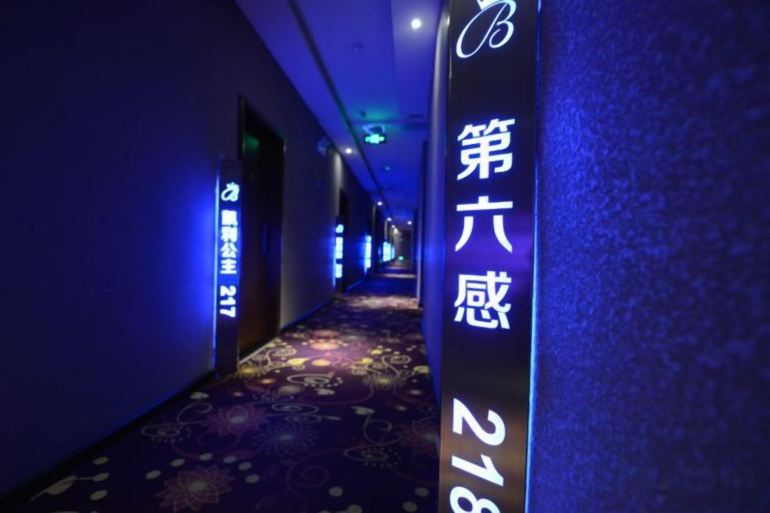 A hotel corridor with a carpeted floor and a sign indicating room number 218.