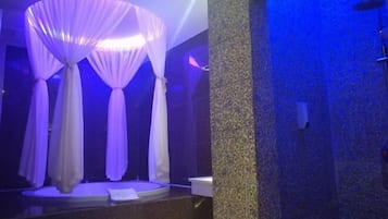 Un baño con un espejo grande, una bañera y una zona de ducha.