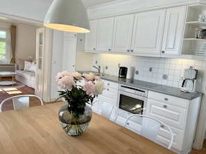 A modern kitchen with white cabinets, a built-in oven, and a coffee maker. - 3 Liv: 55 sqm on three levels offer plenty of space for up to 4 people - country house (Sylt)