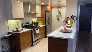 Eine moderne Küche mit Kochinsel, Edelstahlgeräten und Holzschränken.